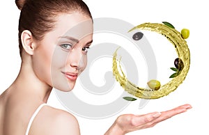 Woman shows circulate splash of olive oil with olives in hand.