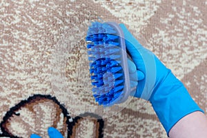 Woman shows dirty brush after cleaning carpets