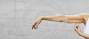 A woman shows the flabby muscles of the arm. Flabby Arm Syndrome (FAS). Banner,