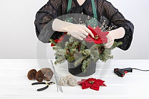 Woman shows how to make Christmas decoration with the poinsettia flower