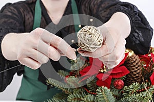 Woman shows how to make Christmas decoration with the poinsettia flower