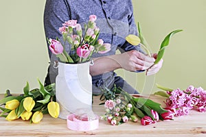 Woman shows how to make spring bouquet with tulip, hyacinth and carnation flowers, tutorial