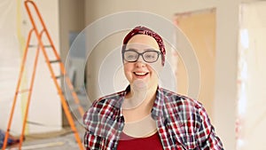 A woman shows the keys to a new apartment where renovations are underway