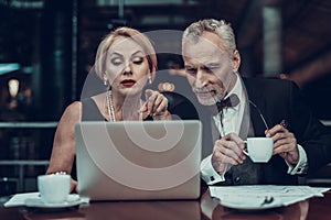 Woman shows on Laptop and Man drink coffee