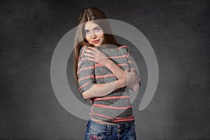 Woman shows the modesty against a dark background