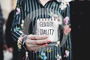 Woman shows notepad with the text gender equality