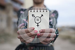 Woman shows notepad with a transgender symbol