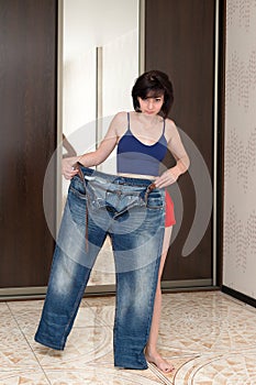 A woman shows off her slim figure, showing off big jeans