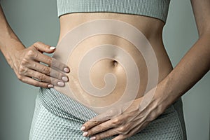 A woman shows a scar from appendicitis on her stomach.