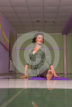 Woman shows yoga exercises in fitness class