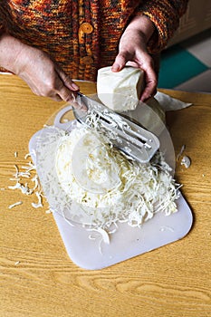 Woman shredding cabbage by manual slaw cutter