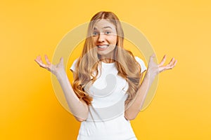 Woman shrugs, with indecisive expression on her face, depicts misunderstanding and uncertainty on a yellow background