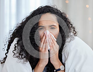 Woman, sick and home with tissue in portrait with blowing nose under blanket for cold, fever and fatigue. Flu, health