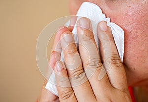 woman sick and sneezing with tissue paper