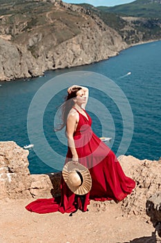 A woman, a side view in a red flying dress fluttering in the wind, a girl in a fluttering dress on the background of the