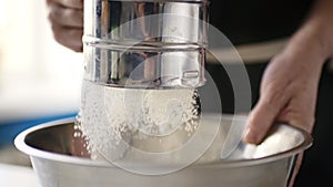 Woman sifting flour in a bowl