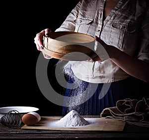 Woman sifting flour through sieve