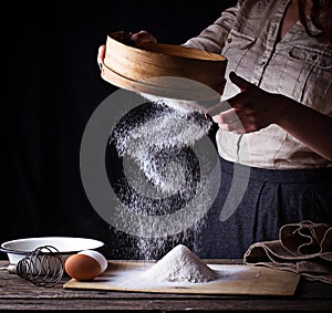 Woman sifting flour through sieve