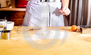 Woman sifting flour through sieve. Prepares the dough