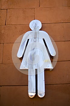 Woman sign (symbol) for toilet on red brick background