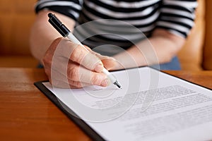 Woman signature document and sitting behind desk