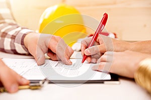 Woman signing construction contract with contractor to build a house