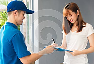 Woman signing delivery in clipboard. get her package from service courier man