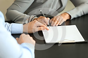 Woman signing document in estate agent's office