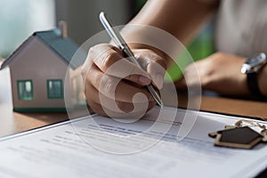 Woman signing loan agreement to buy house through bank broker