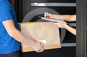 Woman signing parcel delivery papers