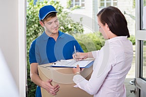 Woman Signing Receipt Of Delivery Package