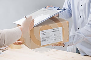 Woman signing receipt of delivery package, close up.