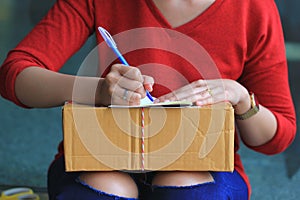 Woman signing receipt of delivery package, shipping and postal service concept