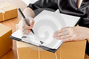 Woman signs clipboard for delivery
