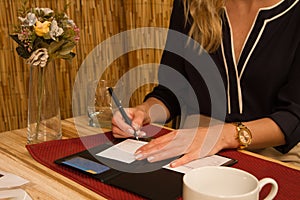 Woman Signs Credit Card Receipt at Restaurant