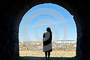 Woman silhouette on a ancient stone tunnel