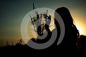 Woman silhouette with bouquet of flowers