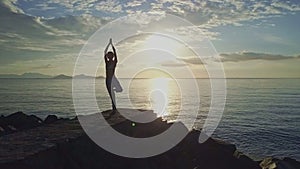 Woman Silhouette Does Yoga against Rising Sun above Ocean