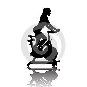 Woman silhouette on exercycle in spinning class