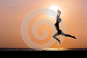 Woman silhouette jumping on sea background