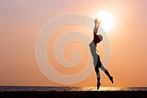 Woman silhouette jumping on sea background