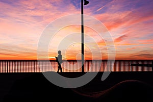 Woman silhouette in La Barceloneta beach at sunrise, Barcelona . Spain photo