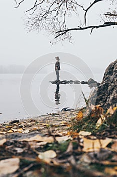 Woman silhouette on the river bank in the morning fog