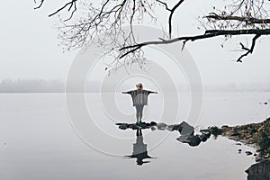 Woman silhouette on the river bank in the morning fog