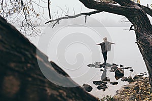 Woman silhouette on the river bank in the morning fog