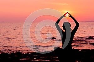 Una mujer silueta en posición sobre el el mar con ilumina 