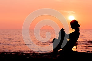 Woman silhouette sitting on sea background