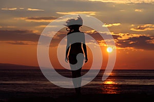 Woman silhouette in sunset beach