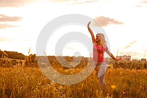 Woman silhouette waiting for summer sun on meadow