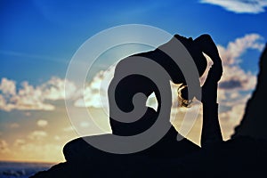 Woman silhouette in yoga pose on sunset sea beach